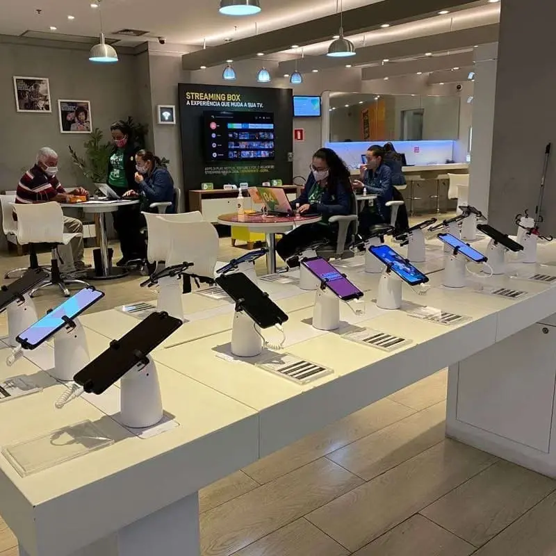 Modern mobile store with rows of retail security display stands protecting demo smartphones